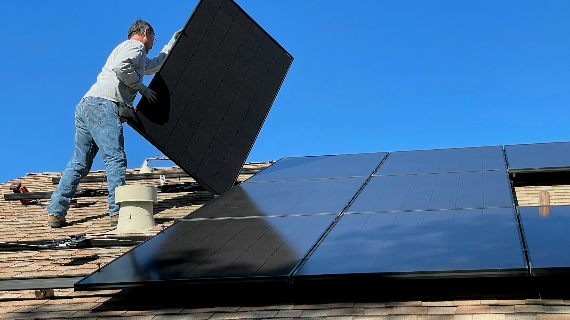 Installer fitting solar panels on a roof