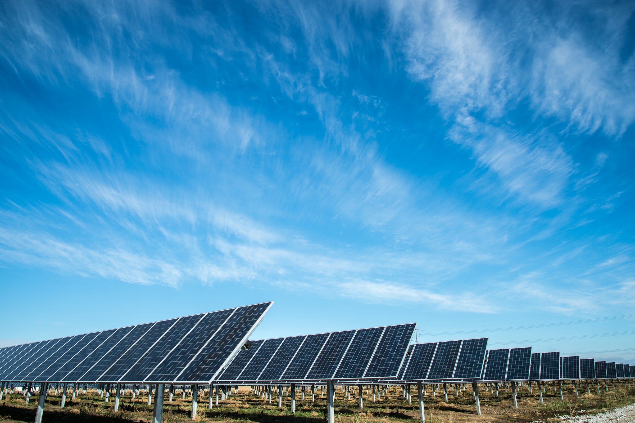Rows of solar panels under a blue sky